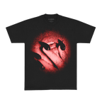 Front view of a black unisex short-sleeve T-shirt displaying a circular photo print with blurred, smeared edges. The image depicts a slightly open mouth partially covered by fingers with long black nails, tinted with a red overlay.
